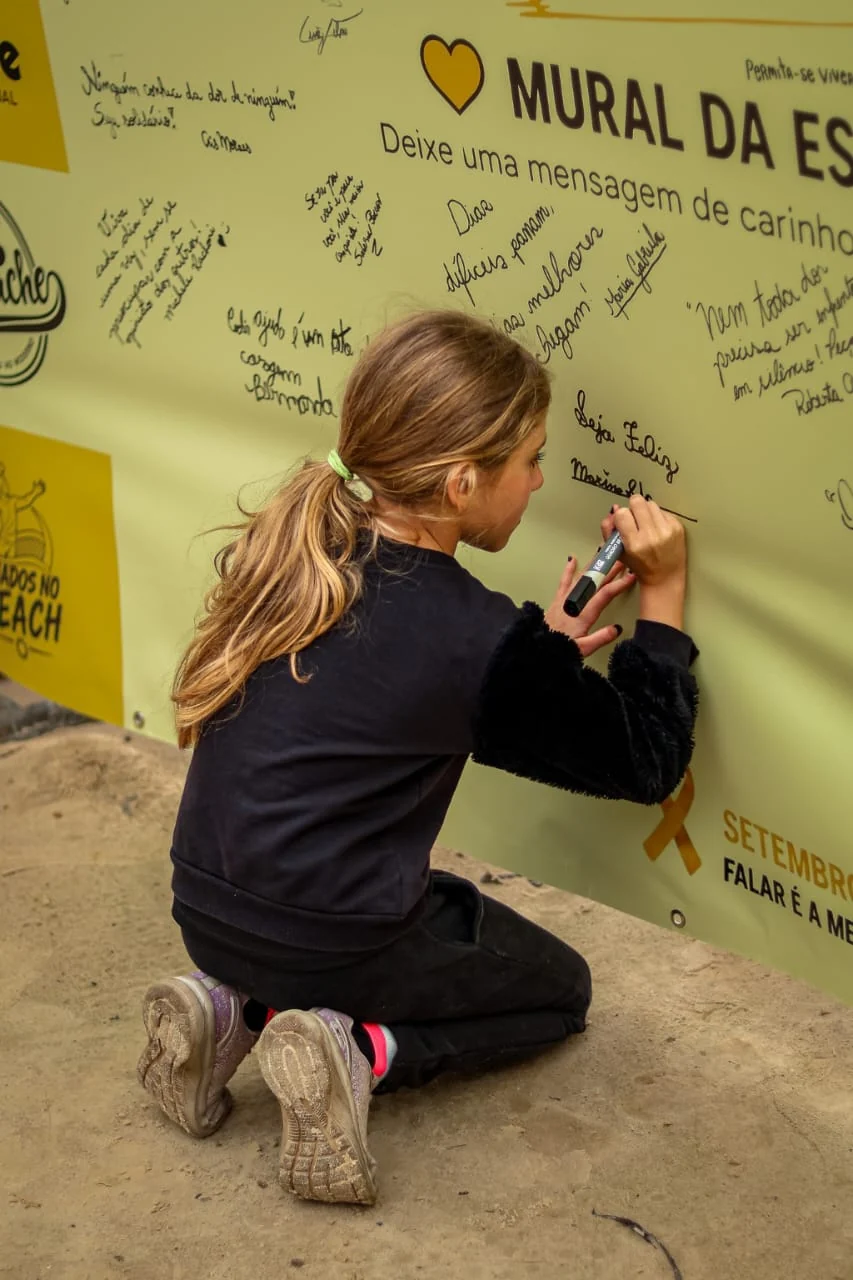 Participante escreve uma mensagem de carinho no Mural da Esperança